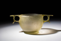 HELLENISTIC GREEN CUT GLASS SKYPHOS

 Ca. 300 - 200 BC A Greek green cut glass skyphos with vertical walls that taper towards the rim and a splayed ...
