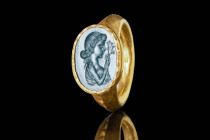 ROMAN GOLD RING WITH DEMETER INTAGLIO

 Ca. AD 300 A large Roman gold ring with a round hoop enlarged on the shoulders to form a large oval bezel. T...