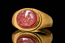 ROMAN CARNELIAN INTAGLIO RING WITH EROTIC SCENE 

 Ca. AD 200 - 300 A Roman gold ring with a carnelian intaglio depicting an erotic scene. The hoop ...