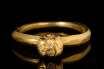 ROMAN GOLD RING WITH PUTTO HEAD

 Ca. AD 100 - 300 A Roman gold ring embellished with a gold head of putto with veristic features. The hair of the p...