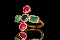 LATE ROMAN GOLD RING WITH EMERALDS AND GARNETS

 Ca. AD 400 - 600 A Late Roman gold ring with five bezels which form a Greek cross. There are two ro...