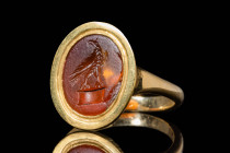 ROMAN CARNELIAN INTAGLIO WITH LEGIONARY EAGLE IN GOLD RING

 Ca. AD 100 - 300 A Roman carnelian intaglio depicting the legionary eagle on a stage, f...