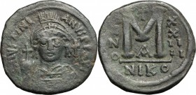 Justinian I (527-565). AE 40 Nummis, Nicomedia mint, 550-551 AD. D/ Bust of Justinian frontal, helmeted holding globus cruciger; over left shoulder, c...