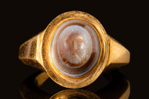 ROMAN GOLD RING WITH AGATE INTAGLIO DEPICTING AN OLD SATYR

 Ca. AD 200 - 300 A polygonal-shaped gold finger ring comprising of a large hoop, large ...