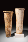 TWO TALL EGYPTIAN ALABASTER JARS

 Predynastic to Early Dynastic Period, Ca. 3100 - 2686 BC A pair of tall Egyptian alabaster jugs with round feet a...