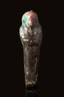 EGYPTIAN FAIENCE USHABTI 

 Late Period, Ca. 664 - 332 BC An Egyptian green/black faience ushabti standing mummiform atop a plinth and holding a pic...