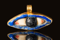 EGYPTIAN GLASS AND OBSIDIAN MUMMY EYE IN LATER GOLD PENDANT 

 Late Period, Ca. 664 - 332 BC An Egyptian pendant with a glass and obsidian eye frame...