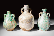 GROUP OF EGYPTO - ROMAN FAIENCE AMPHORISKOI

 Ca. 30 BC - AD 100 A group of three Egypto-Roman green glazed amphoriskoi. The first and the last vess...