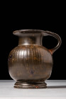 GREEK BLACK GLAZED RIBBED OINOCHOE

 Ca. 450 - 380 BC A black-glazed pottery oinochoe with a globular body with vertical ribbing adorning the body a...