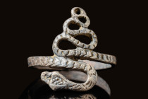 ROMANO-EGYPTIAN BRONZE SNAKE RING

 Ca. 100 BC - AD 200 A Romano-Egyptian bronze ring, flat on the exterior, wound into a six-coil spiral, the tail ...