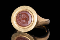 REVIVAL GOLD RING WITH RED JASPER INTAGLIO OF WOLF

 Ca. AD 1800 - 1900 A Roman multi-layer agate intaglio depicting a detailed standing Apollo faci...