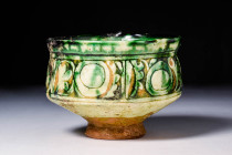 BYZANTINE SGRAFFITO WARE BOWL

 Ca. AD 1100 - 1300 A Byzantine Sgraffito pottery bowl sitting upon an unglazed high foot with a deep basin, all enve...
