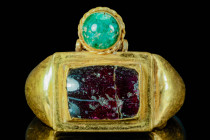 MASSIVE BYZANTINE GOLD RING WITH RECTANGULAR CABOCHON 

 Ca. AD 400 - 600 A massive Byzantine gold ring with double bezel, set with garnet and emera...