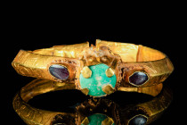 SELJUK / BYZANTINE HEAVY GOLD BRACELET WITH THREE CABOCHONS

 Ca. AD 900 - 1100 A Seljuk/Byzantine heavy gold bracelet with hoop triangular section ...