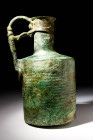 LARGE BYZANTINE BRONZE JUG

 Ca. AD 600 - 800 A bronze jug with a ribbed drum-shaped body, a sloped shoulder, and a cylindrical neck, tapering to a ...
