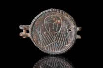 BYZANTINE BRONZE MEDALLION WITH PRAYING SAINT

 Ca. AD 800 - 1000 A Byzantine bronze round medallion incised with a stylised bust of a Saint in a pr...