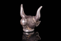 ACHAEMENID SILVER BULL'S HEAD PENDANT 

 Ca. 600 - 500 BC An Achaemenid silver pendant depicting a bull's head with incised eyes, a bulbous snout, a...