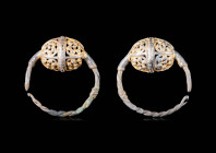 VIKING GILT SILVER OPENWORK EARRINGS

 Ca. AD 800 - 1100 A pair of Viking silver-gilt openwork earrings. Both have an egg-shaped body embellished wi...