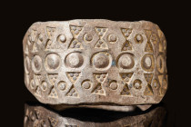 VIKING SILVER RING WITH PRINTED TRIANGLES AND CIRCLES

 Ca. AD 800 - 1100 A Viking silver ring comprised of round terminals and a flat body. The ham...