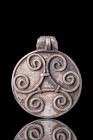 EARLY VIKING SILVER MEDALLION WITH SPIRAL MOTIF

 Ca. AD 600 - 800 An early Viking round medallion, made from silver. The surface is decorated with ...