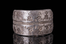 VIKING SILVER RING WITH GEOMETRIC MOTIF

 Ca. AD 800 - 1100 A Viking silver ring composed of a widening band decorated with geometric motifs separat...