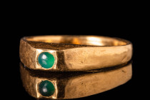 MEDIEVAL GOLD STIRRUP RING WITH EMERALD CABOCHON IN SQUARE BEZEL

Ca. AD 1200 - 1300.
A pretty medieval 21 ct gold ring with a green emerald caboch...