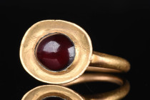 MEROVINGIAN GOLD AND GARNET STONE RING

 Western Europe, Merovingian, Ca. AD 500 - 700 A beautiful gold ring with a circular band and inset garnet c...