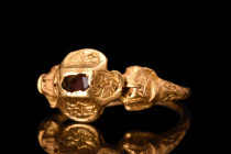 RENAISSANCE GOLD AND GARNET RING

 Ca. AD 1600 - 1700 An ornate, gold ring with scrolled detailing to the shoulders, pyramidal bezel, and inset garn...