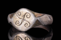 MEDIEVAL SILVER RING WITH SYMMETRICAL MOTIF

 Ca. AD 1200 - 1400 An Early Medieval Byzantine silver ring. The bezel is depicting a double cross. The...