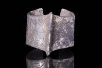 SELJUK SILVER BRACELET WITH STYLISED KUFIC INSCRIPTIONS

 Ca. AD 1000 - 1300 A silver Seljuk penannular bracelet with a central ridge with two oppos...