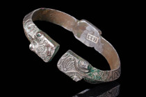 SELJUK HEAVY SILVER BRACELET WITH CALLIGRAPHY

 Ca. AD 1000 - 1200 A Seljuk heavy silver bracelet set with a decorated bezel and two finials on the ...