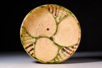 NISHAPUR GLAZED TERRACOTTA BOWL WITH GEOMETRIC MOTIF

 Ca. AD 900 - 1100 A Nishapur pottery bowl sitting upon an unglazed high foot with a deep basi...