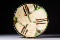 NISHAPUR GLAZED BOWL WITH PHYTOMORPHIC MOTIF

 Ca. AD 900 - 1100 A Nishapur glazed pottery bowl sitting upon an unglazed discoid foot with a deep ba...