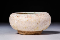 SELJUK GREEN GLAZED BOWL

 Ca. AD 1100 - 1300 A Seljuk green glaze bowl composed of a globular body on a short round foot. The bowl was made with a ...