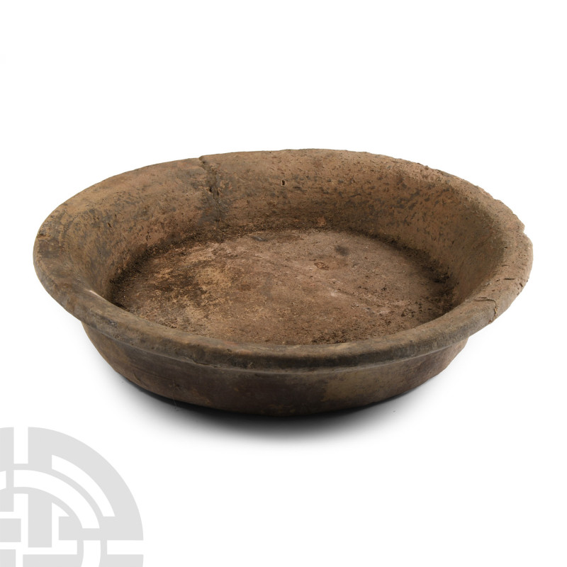 2nd-4th century A.D.. Broad flat base with low sidewall and everted rim; repaire...