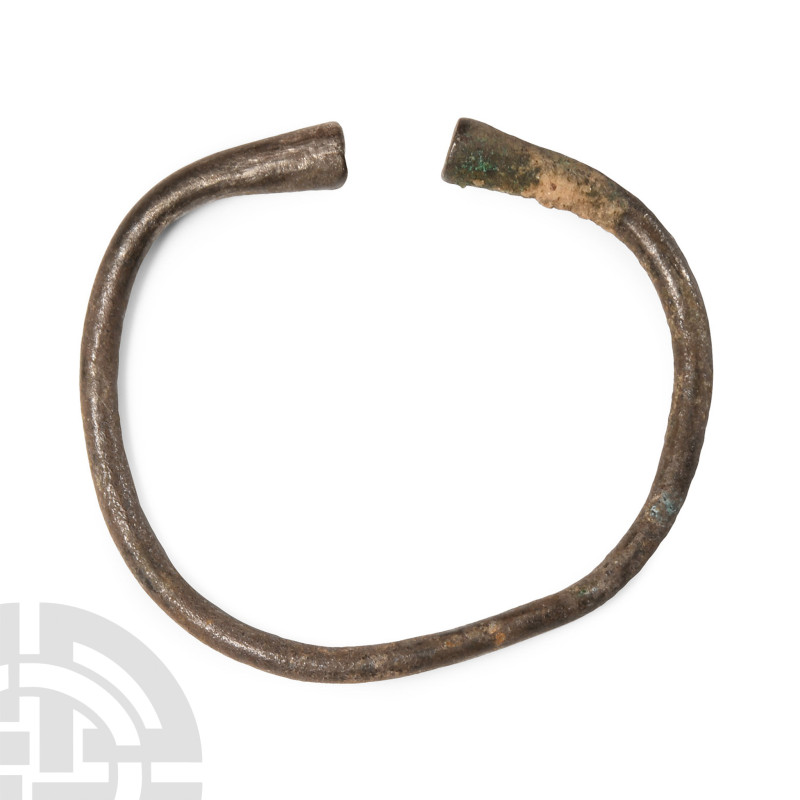 1st millennium B.C.. Penannular round-section hoop with opposed clubbed terminal...