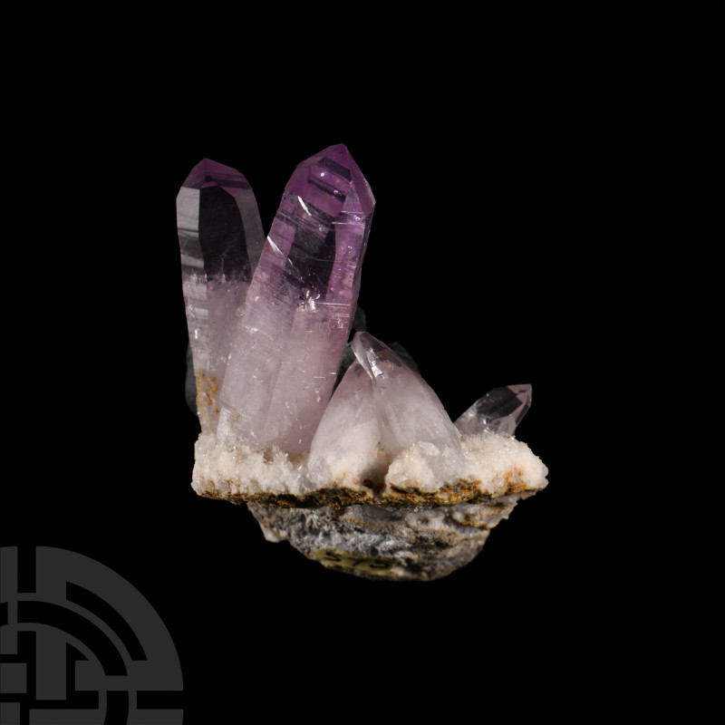 Consisting of two well-formed amethyst crystals extending from a bed of white qu...