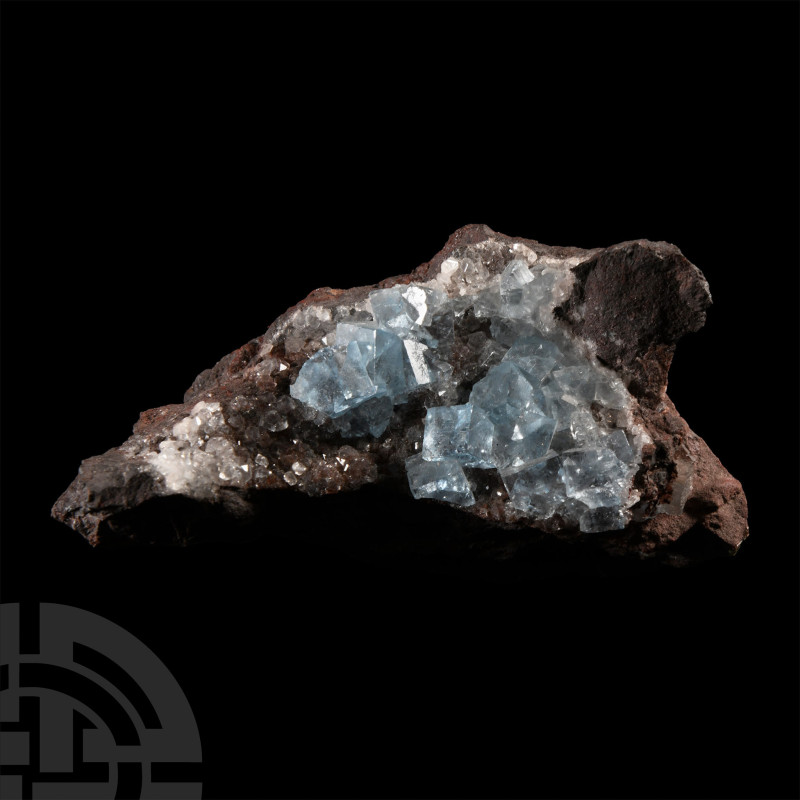 Displaying perfect pale blue fluorite cubes on a hematite matrix with some quart...