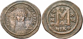 Justinien Ier (527-565), AE follis, an 15, 541-542, Nicomédie. Off. A. D/ B. casqué et cuir. de f., ten. un gl. cr. et un bouclier. A d., une croix. R...