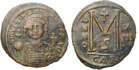 Justinien Ier (527-565), AE follis, an 13, 539-540, Carthage. D/ B. casqué, cuir. de f., ten. un gl. cr. et un bouclier. A d., une croix. R/ Grand  e...