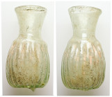 Roman glass unguentarium (AD 3rd–5th centuries)
Greenish glass unguentarium with wide mouth and flared ribbed body.
Weight: 24.12 g.
Diameter: 66.53 m...