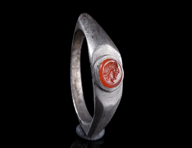 A ROMAN SILVER RING WITH A CARNELIAN INTAGLIO
Circa 3rd century AD.
Ring with ...