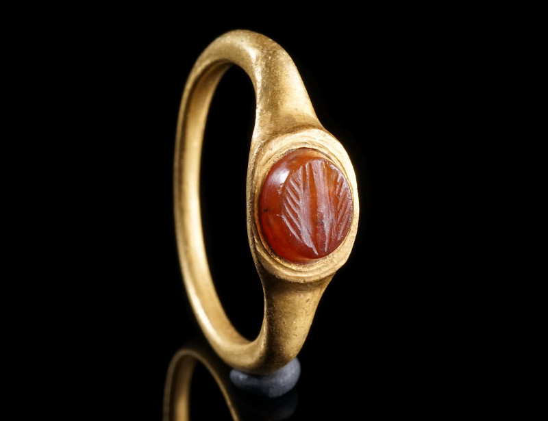 A ROMAN GOLD RING WITH A CARNELIAN INTAGLIO
Circa 2nd century AD.
Ring with an...