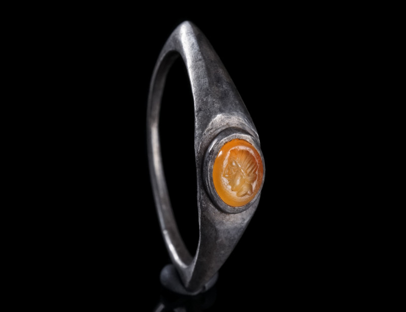 A ROMAN SILVER RING WITH A CARNELIAN INTAGLIO
Circa 3rd century AD.
Ring with ...