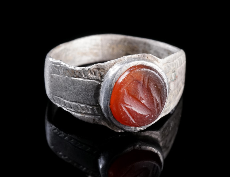 A ROMAN SILVER RING WITH A CARNELIAN INTAGLIO
Circa 3rd century AD.
Ring with ...