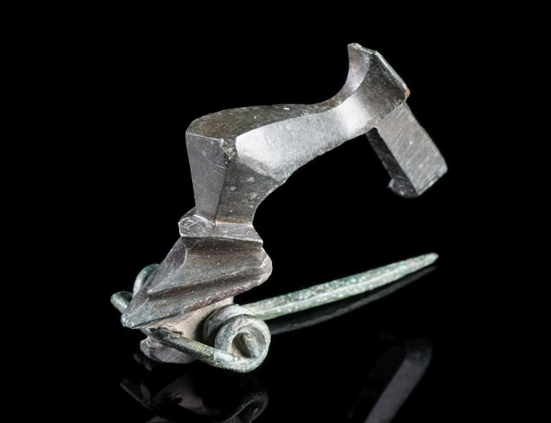 A ROMAN BRONZE KNEE BROOCH
Circa 2nd-3rd century AD.
With facetted bow, triang...