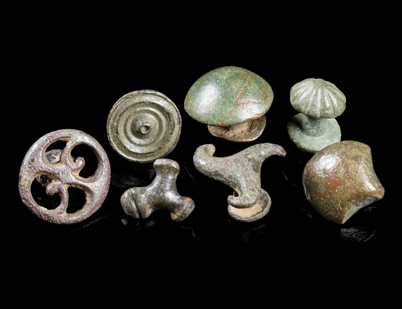 A GROUP OF SEVEN ROMAN BRONZE BELT STUDS/MOUNTS
Circa 2nd-3rd century AD.
Vari...