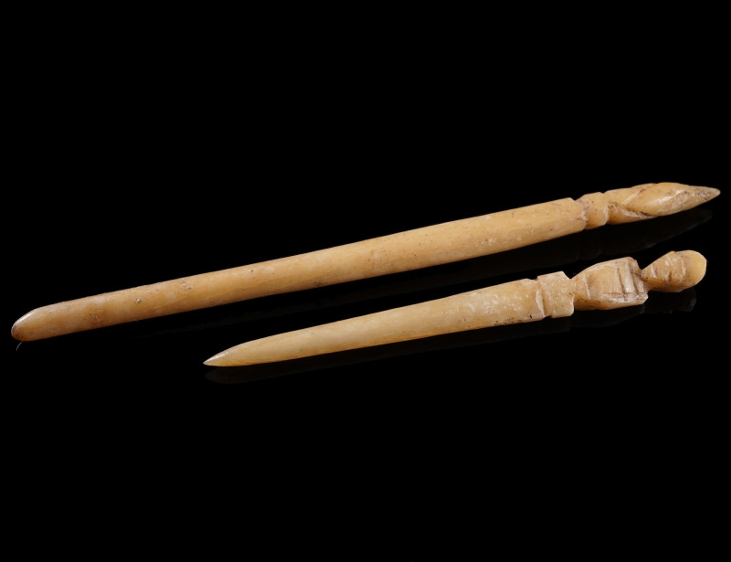 TWO ROMAN CARVED BONE HAIRPINS
Circa 1st-3rd century AD.
One with the head in ...