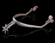 A MEDIEVAL IRON ROWEL SPUR
Circa 14th-15th century AD.
Spur with curved side arms and a seven-pointed rowel. The arms terminating in double-pierced ...