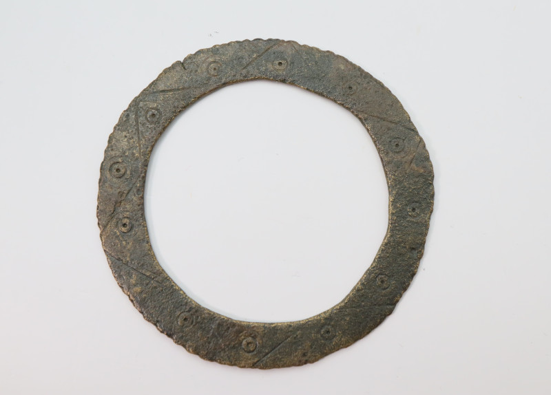 A flat sectioned-substantial bronze pendant with twelve circle and doth decorati...